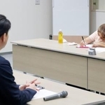 　トライグループの現地研修で「子どもたちに正確に伝えてほしい」と筆談で訴えた、胎児性水俣病患者の古山知恵子さん。手前は阿部正純執行役員＝２日午後、新潟市