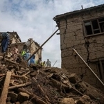 　８月３１日の地震で壊れた家と救助に当たる人たち＝９月２日、アフガニスタン東部クナール州（ロイター＝共同）