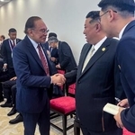 　マレーシアのアンワル首相（左）と握手を交わす北朝鮮の金正恩朝鮮労働党総書記＝３日、北京（アンワル氏のフェイスブックから、共同）