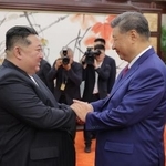 　握手する中国の習近平国家主席（右）と北朝鮮の金正恩朝鮮労働党総書記＝４日、北京（朝鮮中央通信＝共同）