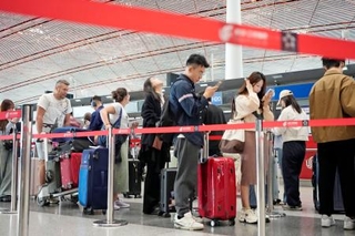 　建国７６年の国慶節を迎え、日本に向かう旅行客らで混雑する北京首都国際空港＝１日（共同）