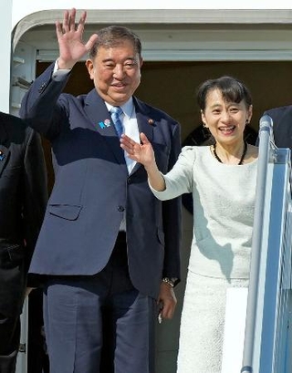　釜山の金海国際空港から帰国の途に就く石破首相。右は妻の佳子さん＝１日（共同）