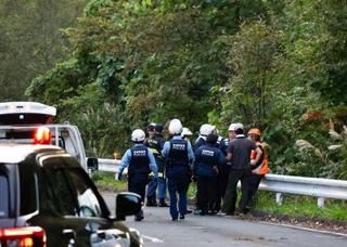 　キノコ採りのグループがクマに襲われた現場付近に集まる、警察官や消防隊員ら＝３日午後、宮城県栗原市