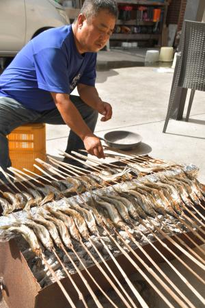 　秋の風物詩、あぶりアユ作りに取り組む木田豪さん＝和歌山県田辺市