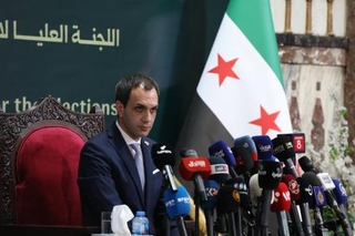 　６日、記者会見するシリア選挙管理委員会の報道官＝ダマスカス（ゲッティ＝共同）