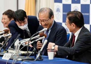 　阿部文科相からの電話を誤って切ってしまい、戸惑う京都大の北川進氏（右から２人目）＝８日午後８時２８分、京都市左京区