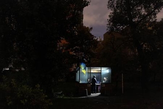 　１０日、ウクライナ各地のエネルギー施設に対する攻撃で停電が発生し、建物に集まる人々＝キーウ（ロイター＝共同）