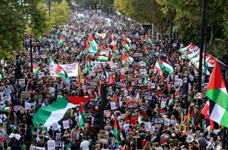 　パレスチナの旗を手に行進するデモ隊＝１１日、ロンドン（共同）