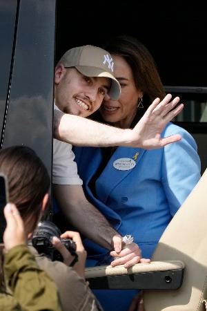 　イスラム組織ハマスから解放され、到着したイスラエルの病院で手を振る人質の男性＝１３日（共同）