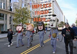 　米ワシントンで「トランプを再び弾劾訴追せよ」と書かれたメッセージを掲げるデモ参加者たち＝１８日（共同）