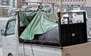 　岩手銀行本店の地下駐車場から、捕獲されたクマを運び出す車両＝２８日午前、盛岡市