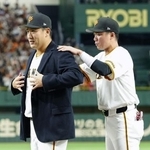 　日米通算２００勝達成を記念するセレモニーで、坂本勇人内野手（右）から受け取った名球会ブレザーを着る巨人・田中将大投手＝１日、東京ドーム