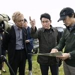 　説明を聞きながら釧路湿原周辺にある大規模太陽光発電所の建設予定地を視察するアルピニストの野口健さん（中央）＝２日午前、北海道釧路市