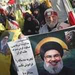 　ヒズボラ前指導者ナスララ師の肖像を手にする男性＝２日、テヘラン（共同）