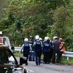 　キノコ採りのグループがクマに襲われた現場付近に集まる、警察官や消防隊員ら＝３日午後、宮城県栗原市