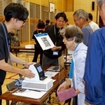 　防災訓練で開設された避難所で、デジタル技術を活用したシステムに情報を登録する住民（右）ら＝５日午前、石川県珠洲市