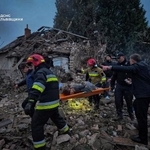 　ロシアの無人機とミサイルによる攻撃で破壊された住宅のがれきの上で、負傷者を搬送する救助隊員ら＝５日、ウクライナ西部リビウ州（ウクライナ非常事態庁提供・ロイター＝共同）