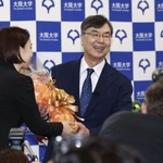 　ノーベル生理学・医学賞の受賞が決まり、笑顔で花束を受け取る大阪大の坂口志文特任教授（右）＝６日午後８時３分、大阪府吹田市