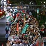 　イスラエルとイスラム組織ハマスの戦闘開始から２年となり、パレスチナ自治区ガザでの戦闘中止を求めてデモ行進する人たち＝７日夜、東京・渋谷