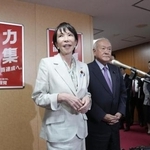 　自民党本部で記者団の取材に応じる高市総裁。右は鈴木幹事長＝７日、東京・永田町