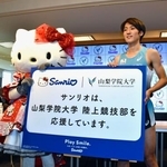 　ハローキティと登場した山梨学院大陸上競技部の平八重充希副主将＝９日午後、甲府市