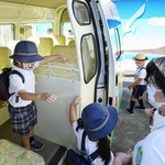 　　東京都内の幼稚園で、バスから降りて登園する園児たち＝２０２２年９月