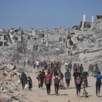 　破壊された建物の間を歩く人たち。イスラエルとイスラム組織ハマスの停戦が発効した＝１０日、ガザ北部ガザ市（ＡＰ＝共同）