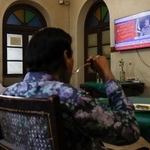 　パキスタン軍の記者会見を報じるテレビを見る人たち＝１０日、パキスタン南部カラチ（ロイター＝共同）