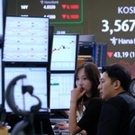 　韓国・ハナ銀行のディーリングルームで株価指数を見つめるトレーダーら＝１３日・ソウル（ＡＰ＝共同）