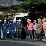 　クマに襲われたとみられる従業員が行方不明になった温泉旅館「瀬美温泉」で、捜索の準備をする警察官と猟友会のメンバー＝１７日午前、岩手県北上市