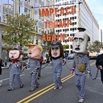 　米ワシントンで「トランプを再び弾劾訴追せよ」と書かれたメッセージを掲げるデモ参加者たち＝１８日（共同）