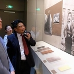 　内山完造と魯迅が写った写真（右）を眺める上海市人民対外友好協会の関係者ら＝１９日、中国上海市（共同）