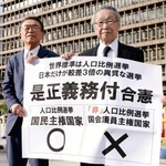 　「１票の格差」訴訟の判決を受け、大阪高裁前で「是正義務付合憲」などと書かれた紙を掲げる原告側の升永英俊弁護士（右）ら＝２４日午後