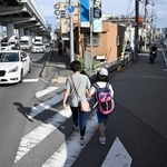 　通学に同行し、支援するヘルパー（左）＝９月、大阪府豊中市