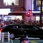 　天皇陛下との会見のため皇居へ向かうトランプ米大統領を乗せた車。沿道では大勢の人がスマートフォンを向けていた＝２７日夜、東京都港区