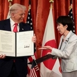 　会談後、署名した文書を手にする高市首相（右）とトランプ米大統領＝２８日、東京・元赤坂の迎賓館（ロイター＝共同）