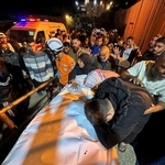 　２８日、パレスチナ自治区ガザ南部ハンユニスの病院で、イスラム組織ハマスの空爆で死亡した人のそばに集まる人々（ロイター＝共同）