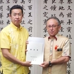 　沖縄県の玉城デニー知事（右）から要望書を受け取る黄川田沖縄北方相＝２９日午後、沖縄県庁