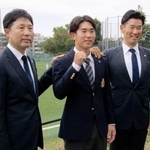 　西武からドラフト１位で指名され、写真に納まる明大の小島（中央）。右は西武の広池浩司球団本部長＝３１日、東京都府中市