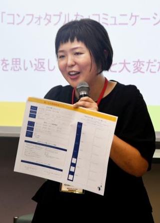 　武蔵野大で開かれた交流会で、「聞こえの説明書」の作り方を伝える志磨村早紀さん＝９月、東京都西東京市