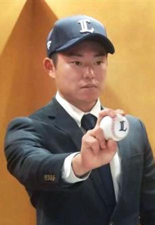 　西武入りが決まり、ポーズをとる育成ドラフト６位で指名された上智大の正木悠馬投手＝５日、東京都内