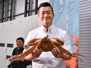 　４５０万円で落札した石川県のブランドガニ「輝」を手にする旅館関係者＝６日夜、金沢市