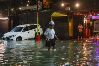 　台風が直撃し浸水した道路を歩く男性＝９日、マニラ首都圏（ゲッティ＝共同）