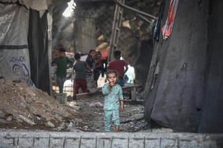 　イスラエル軍の攻撃で損壊した建物で暮らすガザ北部ガザ市の子ども＝１０日（ゲッティ＝共同）