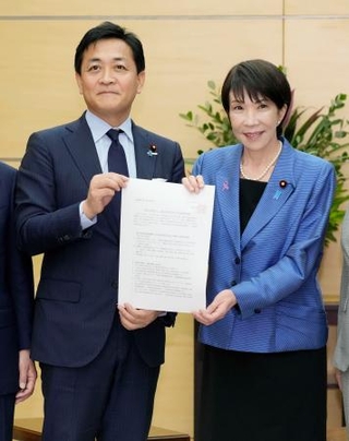 　経済対策の策定に向けた国民民主党の提言を高市首相（右）に手渡す玉木代表＝１２日午後、首相官邸