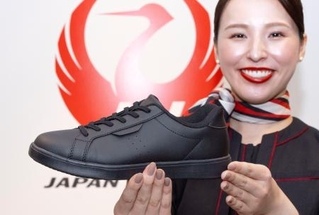 　スニーカーを持つ客室乗務員＝１３日午前、東京都大田区