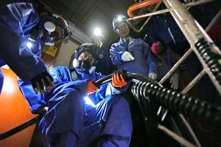 　新潟県の柏崎刈羽原発６号機原子炉建屋内で行われた、外部電源を確保する訓練を視察する花角英世知事（右）＝１４日午前