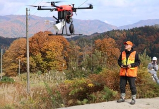 　クマが嫌がる音を出すドローンを飛ばす業者＝１４日午後、岐阜県飛騨市