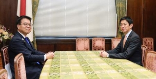 　会談に臨む国民民主党の浜口政調会長（左）と自民党の小林政調会長＝１４日午後、国会