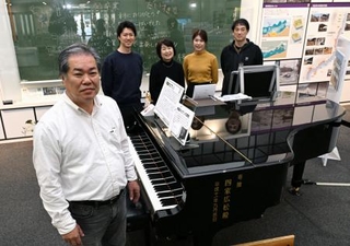 　大規模修復が必要になった「奇跡のピアノ」を囲む調律師遠藤洋さん（手前）と家族＝１０月、福島県いわき市